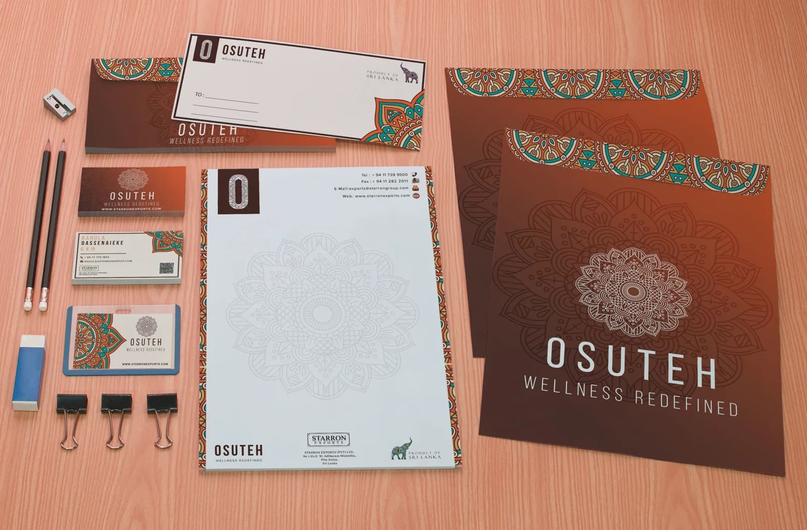 OSUTEH stationery on a wooden desk: letterhead, business cards, envelopes and two brown folders with a mandala emblem.